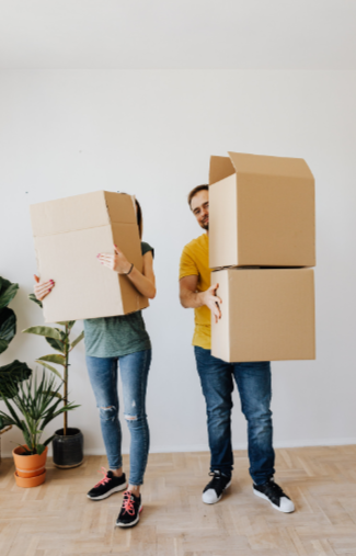 happy couple packing moving cardboard boxes